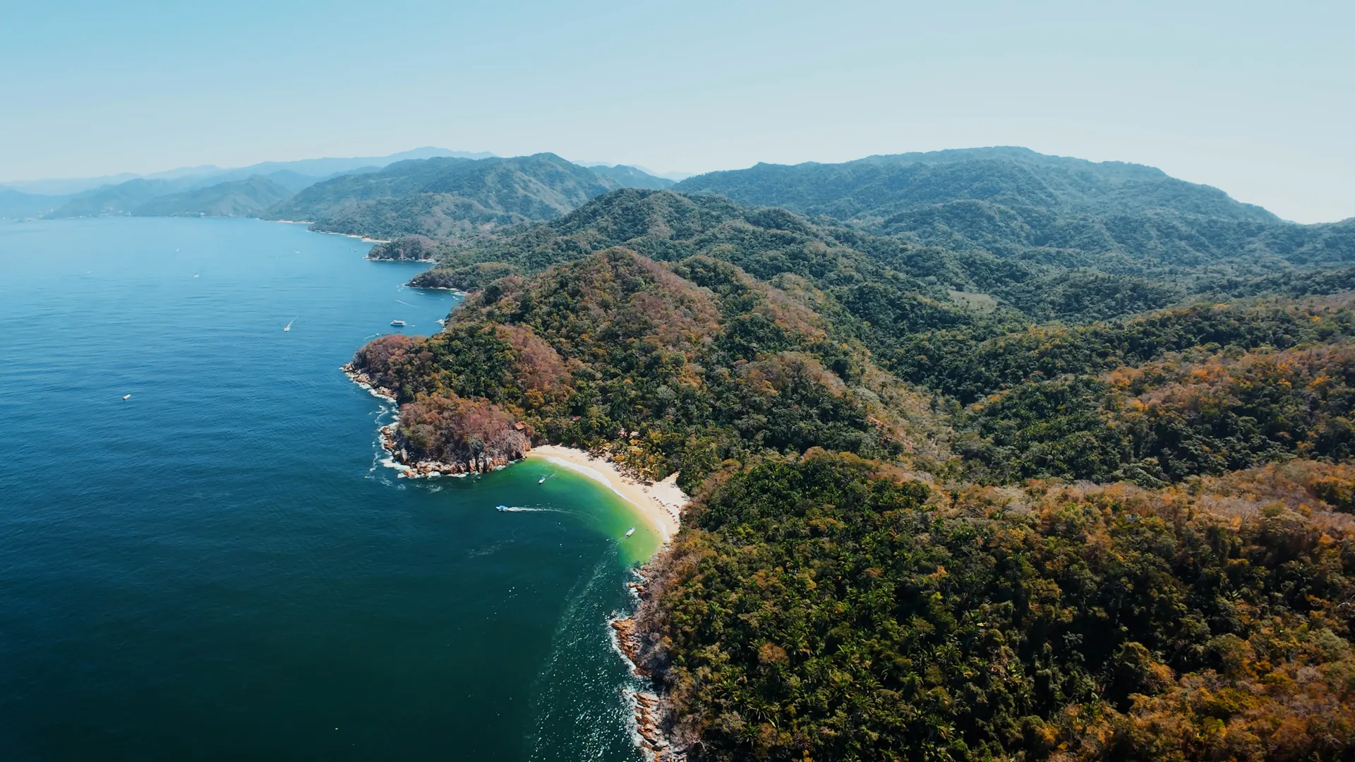 Aerial view of the jungle coastline and Majahuitas beach cove on the south shore of Banderas Bay
