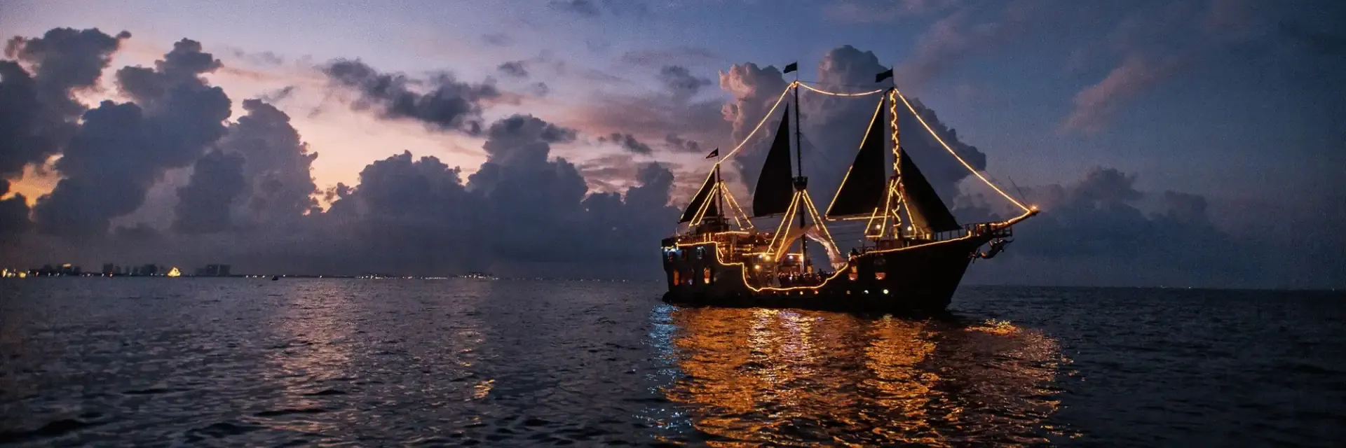 The pirate ship lit up at dusk on Banderas Bay