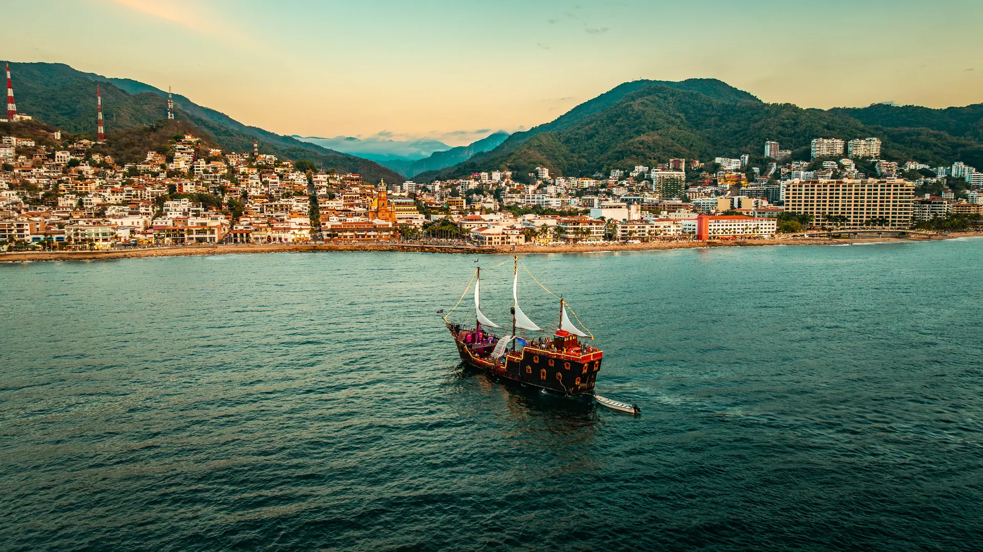 Aerial view of the pirate ship sailing past the Puerto Vallarta Malecon, old town and Guadalupe church